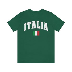Pu&ograve; includere: Una maglietta verde con la scritta "ITALIA" in lettere bianche e la bandiera italiana stampata sotto.