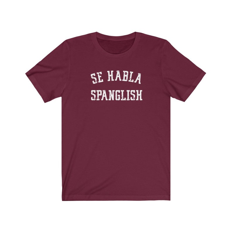 May include: Burgundy short-sleeved t-shirt with white text that reads "Se Habla Spanglish".
