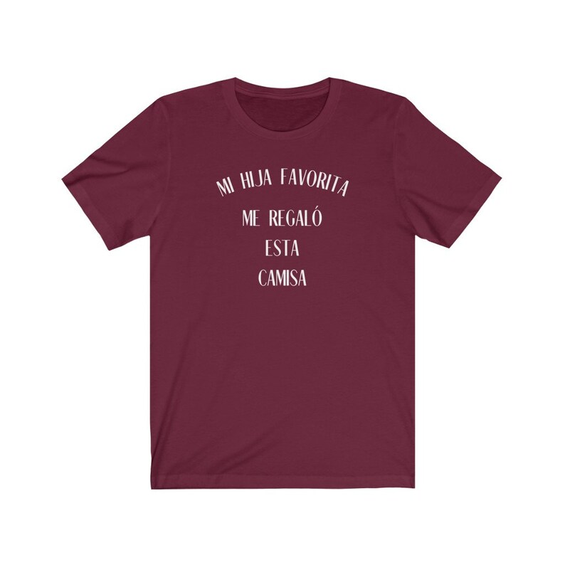 May include: Burgundy t-shirt with white text that reads "Mi hija favorita me regal&oacute; esta camisa".