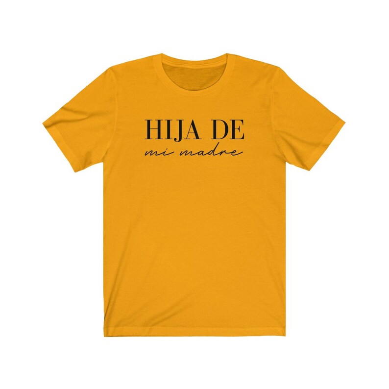 May include: A yellow t-shirt with black text that reads "HIJA DE mi madre".