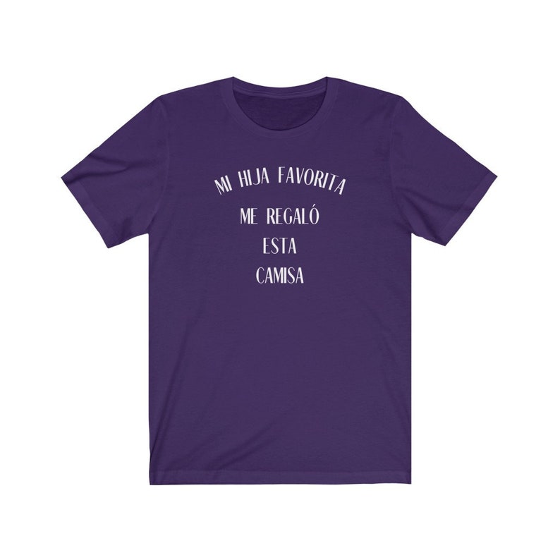 May include: Purple t-shirt with white text that reads "Mi hija favorita me regal&oacute; esta camisa".