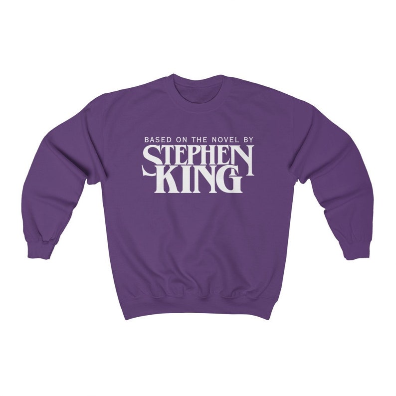 May include: Purple sweatshirt with white text that reads "Based on the novel by Stephen King"