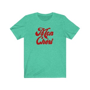May include: A teal blue t-shirt with the words "Mon Ch&eacute;ri" in red retro font.