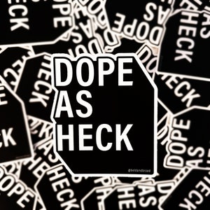 May include: Black and white sticker with the text "Dope as Heck" in a bold, sans-serif font. The sticker is shaped like a stop sign and has a white border. The text "@boldandbroad" is in a smaller font at the bottom of the sticker.