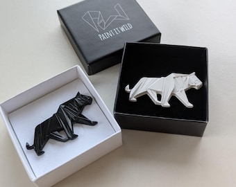 May include: Two origami tiger paperweight figurines in black and white, displayed in their individual boxes. The boxes are white with black trim and black with white trim. The boxes have the text "Paint It Wild" printed on them.