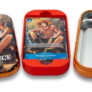 May include: An open orange tin with a silver interior next to a red card holder containing a trading card. The card features a character illustration. The tin on the left has the text "ONE PIECE CARD GAME".