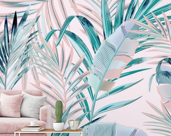 May include: A pink sofa with two pillows sits in front of a wall with a tropical leaf pattern in shades of blue and green. The leaves are stylized and have a watercolor effect.