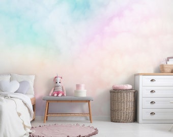 May include: A white bedroom with a pastel rainbow cloud wall mural. A white bed with a white comforter and a unicorn stuffed animal on a wooden bench. A white dresser with a teddy bear on a white chair.