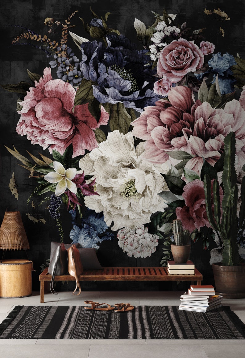 May include: A dark floral wallpaper mural with a large bouquet of pink, white, and blue flowers. The wallpaper is displayed in a living room setting with a wooden bench, a rug, and a lamp.