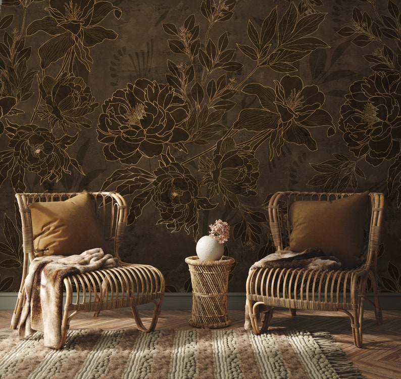 May include: Two wicker chairs with brown cushions sit in front of a wall with a brown floral wallpaper pattern. A small table with a vase of pink flowers sits between the chairs.