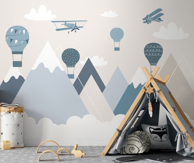 May include: A light blue, gray, and white nursery wall mural with a mountain range, clouds, hot air balloons, and airplanes. The mural is perfect for a child's room.