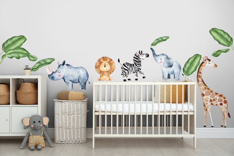 May include: A nursery room decorated with a jungle theme. The wall is decorated with watercolour animal stickers, including a rhino, lion, zebra, elephant, and giraffe. The stickers are surrounded by green leaves. A white cot with a white mattress is in the centre of the room. A stuffed elephant toy is on the floor.