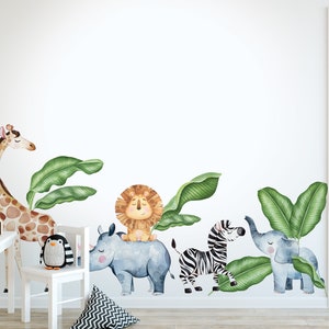 May include: A set of watercolour animal wall decals featuring a giraffe, lion, rhino, zebra, and elephant. The decals are surrounded by green banana leaves. The decals are perfect for a nursery or child's room.