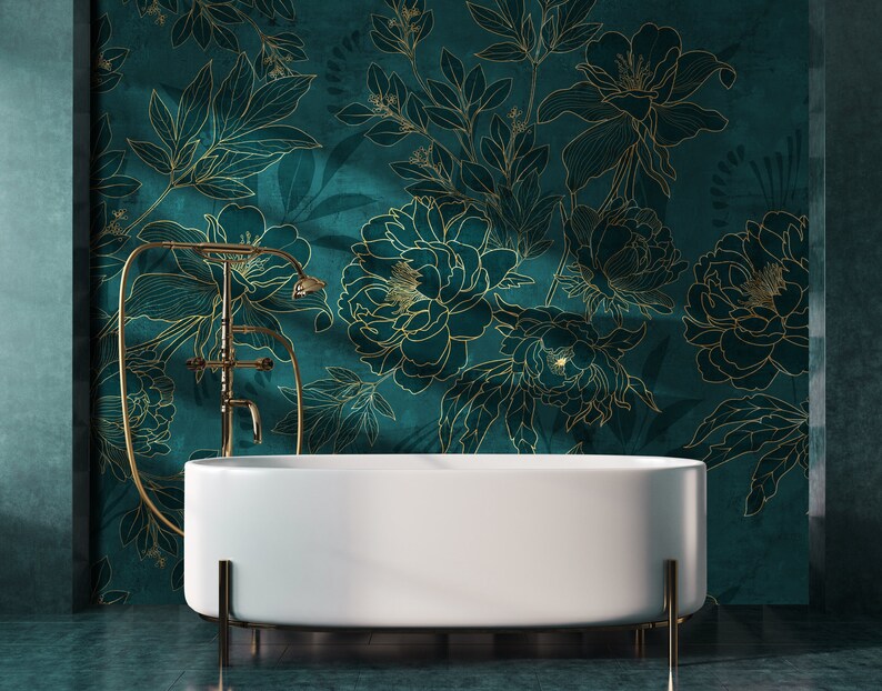 May include: A white freestanding bathtub with gold-toned legs sits in front of a teal green wall with a gold floral pattern.