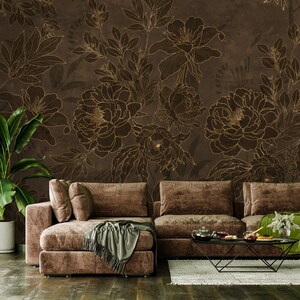 May include: A brown sectional sofa with a throw blanket and pillows in a living room with a brown floral wallpaper featuring gold outlines.