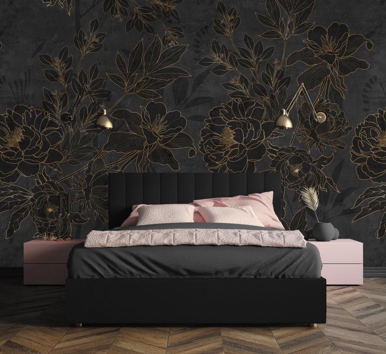 May include: A black upholstered bed with a headboard featuring a tufted design. The bed is positioned in front of a wall with a black and gold floral wallpaper. The wallpaper features a large-scale floral pattern with delicate gold outlines.