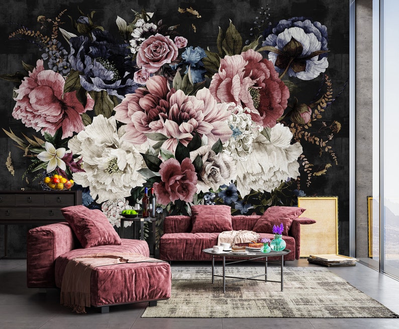 May include: A living room interior with a floral wallpaper featuring a large bouquet of pink, white, and blue flowers. A plush pink sectional sofa with a coffee table and a vase of flowers sits in front of the wallpaper.
