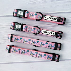 May include: Four pink dog collars with a unicorn and palm tree print. The collars have black buckles and the text "PUPPERZ" on them.