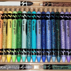 May include: A set of 28 glitter gel pens in a variety of colors, including black, red, orange, yellow, green, blue, purple, pink, and gray. The pens are arranged in a clear plastic case.