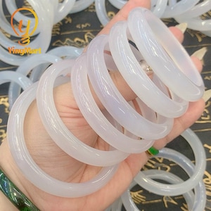 May include: A stack of white jade bangles, a type of traditional Chinese jewelry.