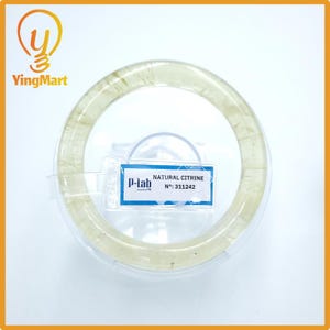May include: A natural citrine bracelet, presented in a clear plastic container. The bracelet is a light yellow color and appears to be made of polished stones. A label reads "NATURAL CITRINE" and "No: 311242".