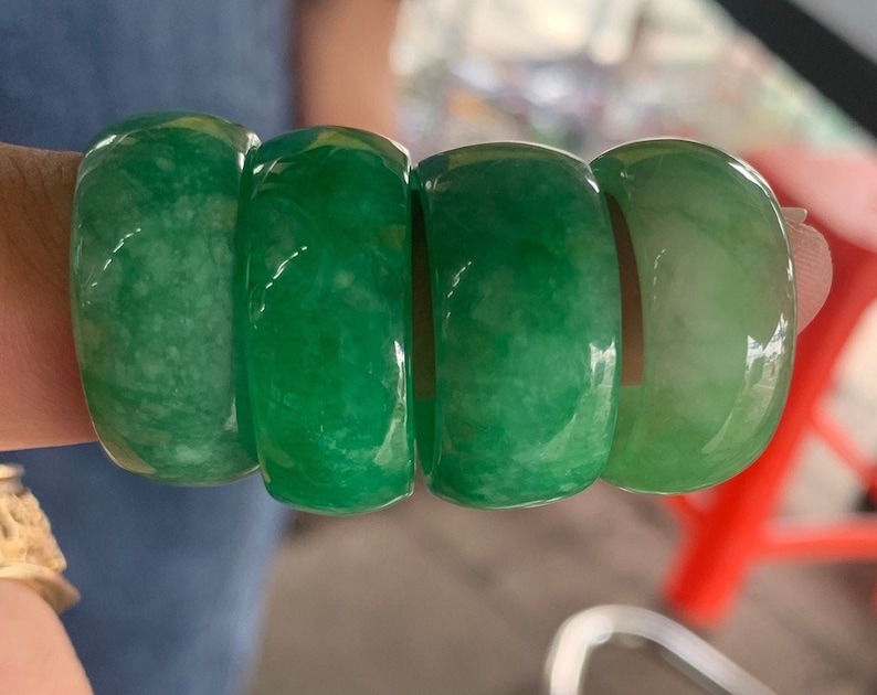 May include: Four jade rings stacked together. The rings are a light green color and have a smooth, polished finish.