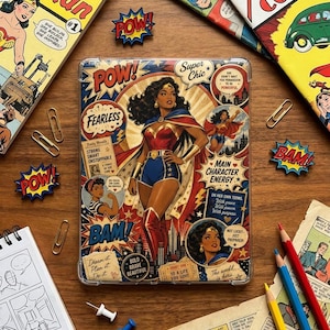 May include: A rectangular tablet case featuring a vibrant comic book collage design. The central illustration depicts a superheroine in a red, blue, and gold costume. Text elements include POW, Super Chic, FEARLESS, and MAIN CHARACTER ENERGY.