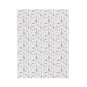 White fabric with a repeating pattern of snowmen. Each snowman has a red hat, green scarf, and twig arms. The background is white with small, scattered snowflakes. A festive, winter-themed design.