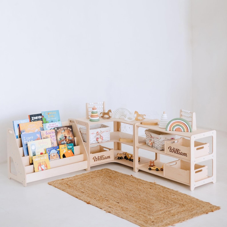 May include: A wooden bookshelf with a built-in book holder and a name tag that says "William". The bookshelf is filled with children's books and has a small toy car on the bottom shelf.