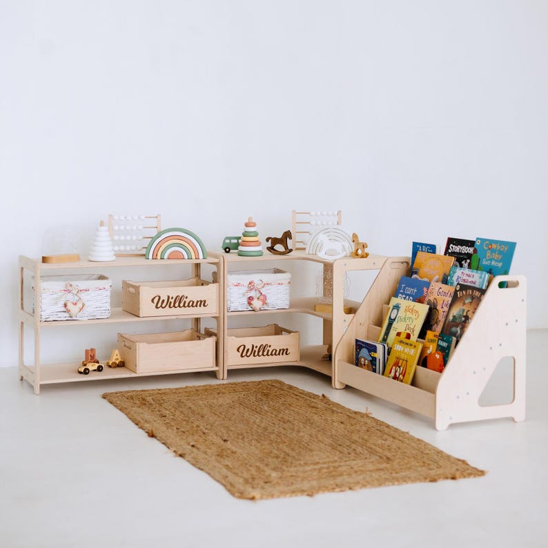 May include: A light wood children's bookshelf and storage unit with the name "William" on the storage boxes. The unit holds books, toys, and decorative items. A woven rug is on the floor.