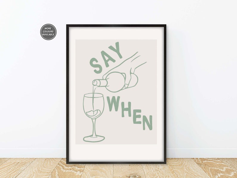 Pode incluir: Uma impress&atilde;o emoldurada com um fundo bege claro e texto verde que diz "SAY WHEN". Uma m&atilde;o est&aacute; a verter vinho de uma garrafa para um copo.
