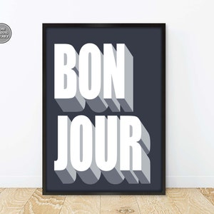 May include: A black framed print with a white background and the text "BONJOUR" in white with a gray shadow effect.