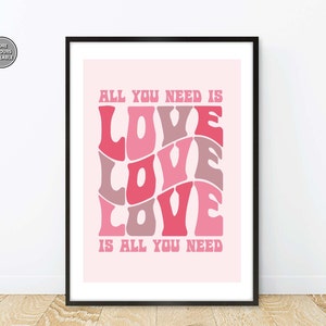 May include: Pink and white poster with the text "All you need is LOVE is all you need" in a retro font style.