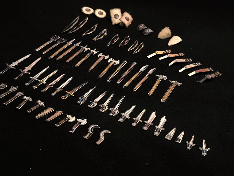 May include: A collection of miniature fantasy weapons, including swords, axes, hammers, and bows, arranged on a black surface. The weapons vary in size and design, with silver and brown tones. Some have shields and other accessories.