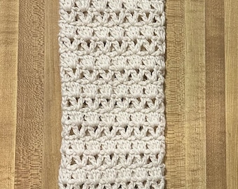 May include: A crocheted cream-colored bag with a loop handle. The bag is made with a delicate open stitch pattern.