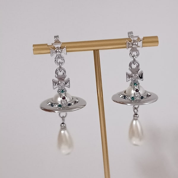 Vivienne Westwood- Boucles d'oreilles en plaqué argent avec des perles synthétiques, des cristaux et saturne.