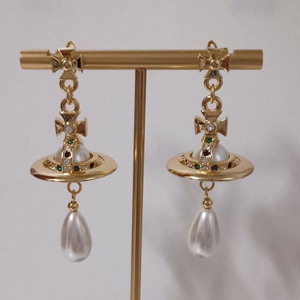 Vivienne Westwood- Boucles d'oreilles en plaqué or avec des perles synthétiques, des cristaux et saturne.
