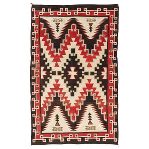 May include: Rectangular woven rug with a geometric pattern in red, black, and cream. The rug features a central design with a cross-like shape and repeating triangular and stepped patterns. A border of red and black squares frames the design.