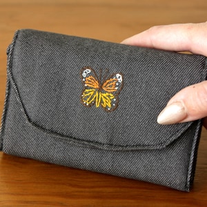 Carteras con mariposas bordadas a mano.