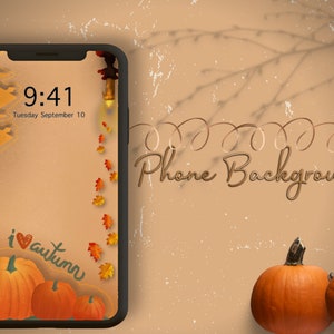 May include: A phone screen with a fall-themed background. The screen displays the time 9:41 and the date Tuesday September 10. The background features a brown and orange gradient with falling leaves and a pumpkin design. The text "i love autumn" is written in cursive on the screen. The phone is on a brown surface with two pumpkins in the foreground.