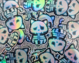 Può includere: Una collezione di adesivi olografici iridescenti con simpatici gatti dei cartoni animati con disegni scheletrici. Gli adesivi sono in varie pose e presentano uno schema di colori blu e bianco.