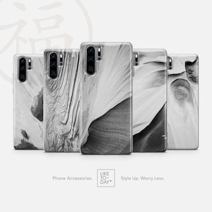 Puede incluir: Cinco fundas de teléfono en blanco y negro con diferentes diseños abstractos. Las fundas son de plástico transparente y muestran una variedad de texturas y patrones. Las fundas son todas para el mismo modelo de teléfono, que tiene una lente de cámara triple.