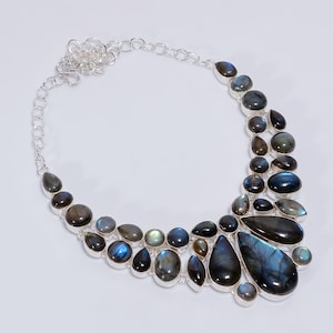 Peut inclure: Un collier en argent avec un design en cascade de pierres de labradorite bleu foncé. Les pierres sont facettées et ont une forme de poire.