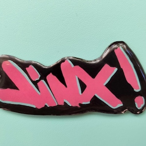 May include: A black and pink sticker with the word "Lixx!" written in a stylized font.