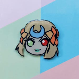 May include: A cartoon character with blonde hair, a crescent moon headband, and green and red eyes. The character is wearing a light brown outfit and has a light green background.
