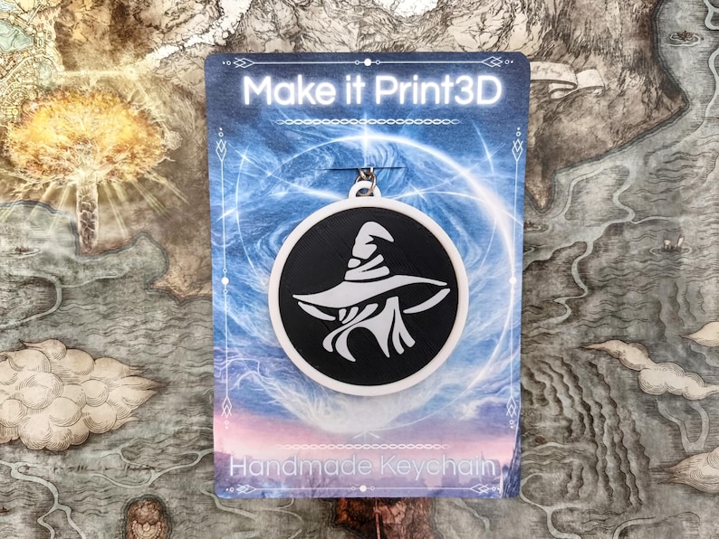 May include: A black and white witch hat keychain. The keychain is round with a black background and a white witch hat design. The card behind the keychain says "Make it Print3D" and "Handmade Keychain".