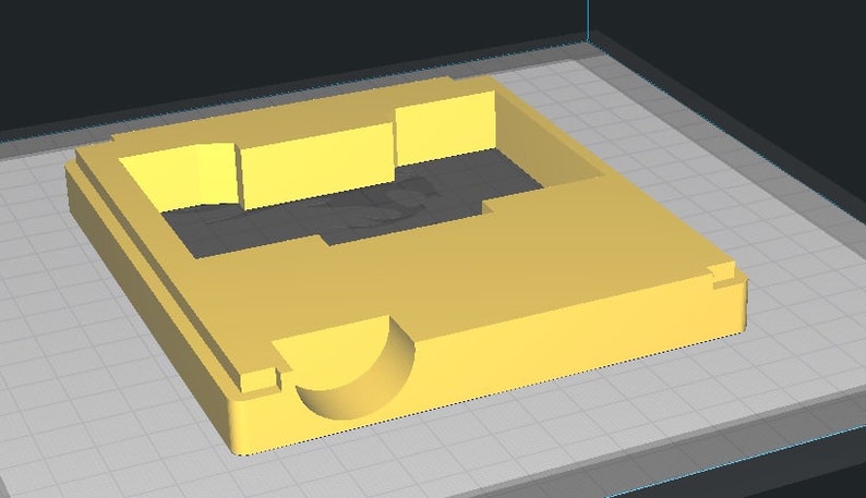 May include: A yellow plastic mold with a rectangular opening and a curved indentation on one side.