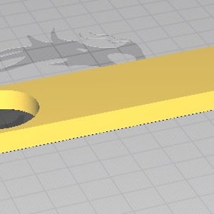 May include: A yellow plastic rectangular block with a round hole in the center. The block is on a gray grid background.
