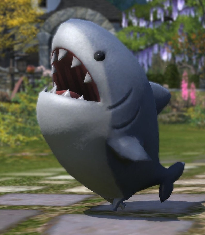May include: A cartoon shark with a gray body and white belly, fins, and teeth. The shark has a wide open mouth, revealing sharp teeth. The shark is standing on a grassy surface.