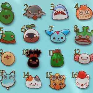 May include: Set of 16 colorful enamel pins featuring various cartoon characters. The pins are numbered 1 through 16 and feature a variety of designs, including a shark, a frog, a mushroom, a cat, and a fish.